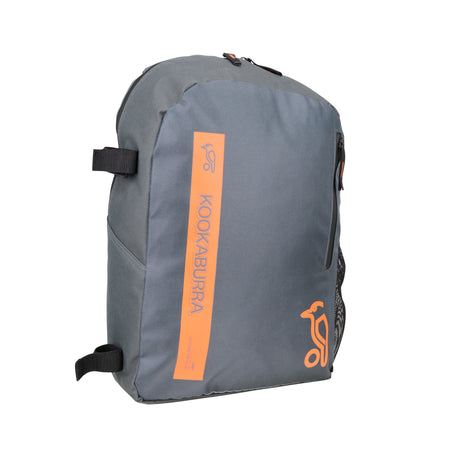The Kookaburra Orbit Hockey Rucksack 2025 is a grey junior bag with black adjustable straps, an orange Kookaburra logo and label on the front, and a zippered front pocket.
