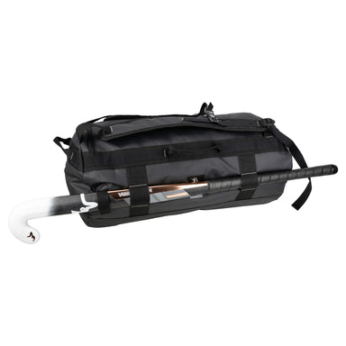 The Kookaburra Pro Switch Holdall by Kookaburra is a black heavy-duty tarpaulin bag designed for multiple uses, shown with a hockey stick partially inserted in the side pocket, with its handle and white curved blade visible.