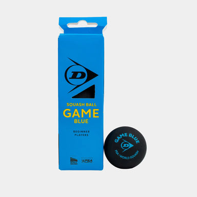A blue Dunlop box labeled “Game Blue” stands upright next to a black Dunlop beginner squash ball featuring the “Game Blue” name and branding in blue text. The packaging is designed specifically for beginner players and contains four boxes, each with three balls.
