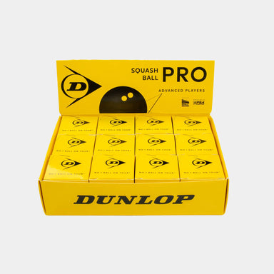 A yellow Dunlop display box containing 12 individual boxes of Dunlop Pro Squash Balls, professional-grade squash balls designed for advanced players who prefer a low-bounce ball.