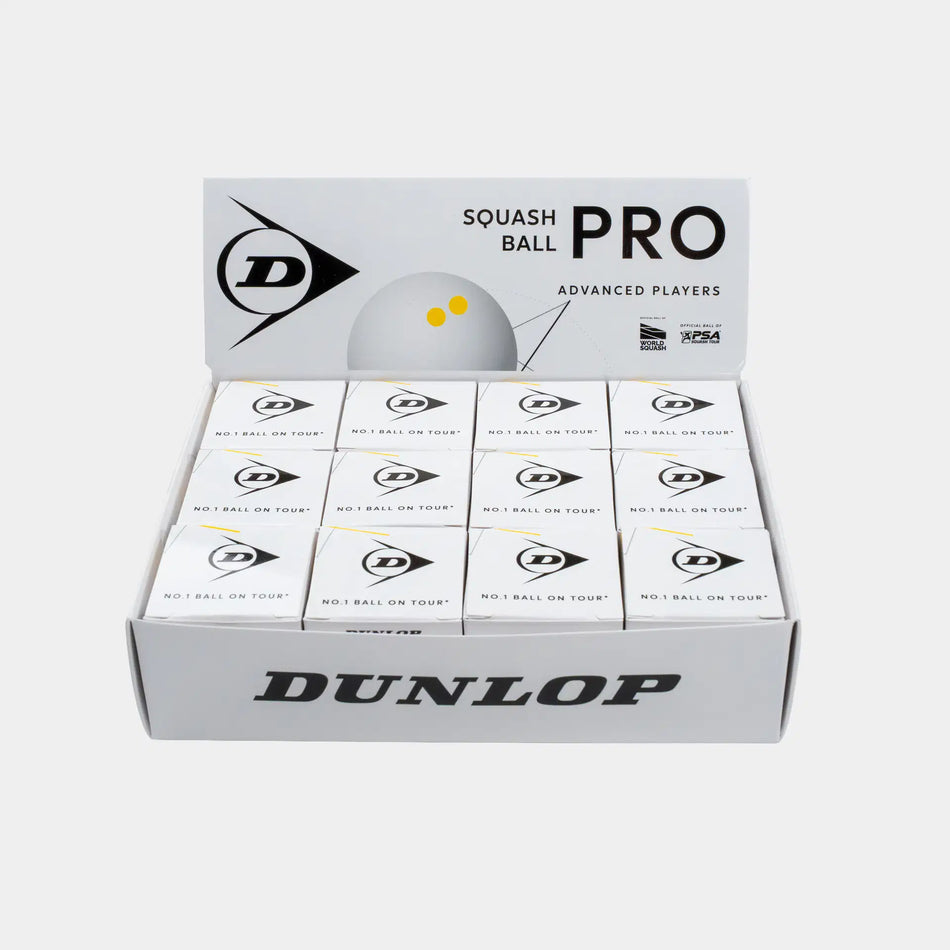 An open display box contains twelve individual Dunlop Pro White Squash Ball boxes, each labeled for advanced players and featuring the Dunlop logo along with “No.1 Ball on Tour!” text. This product is ideal as a low bounce squash ball, specifically designed for competitive play on glass courts.