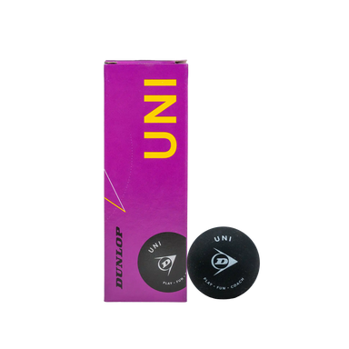 A purple box of Dunlop Uni Squash Balls (3 Ball Box) stands upright next to a black Dunlop Uni Squash Ball, making it ideal for beginners or coaching sessions, all set against a white background.
