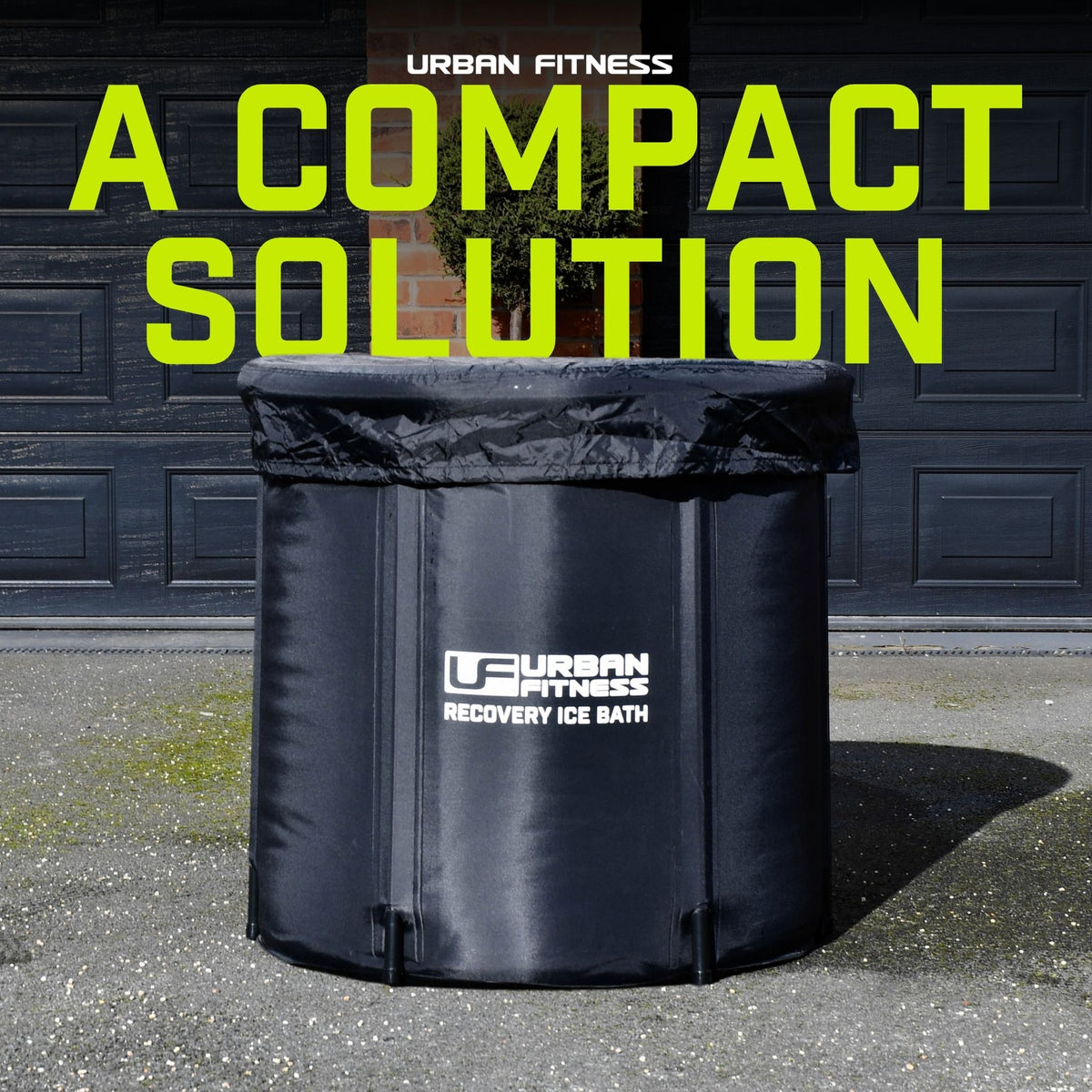 A black Urban Fitness Recovery Ice Bath by Urban Fitness sits on pavement outside a closed garage door. Above it, large green text reads "A COMPACT SOLUTION.