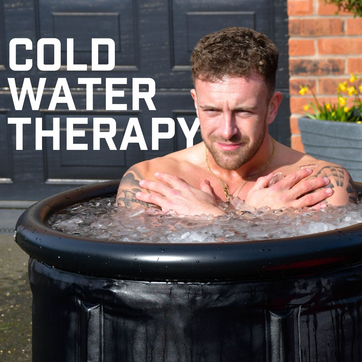 A man sits in the Urban Fitness Recovery Ice Bath by Urban Fitness, arms crossed over his chest. The words “COLD WATER THERAPY” highlight ice bath recovery benefits, with a brick wall and door in the background.