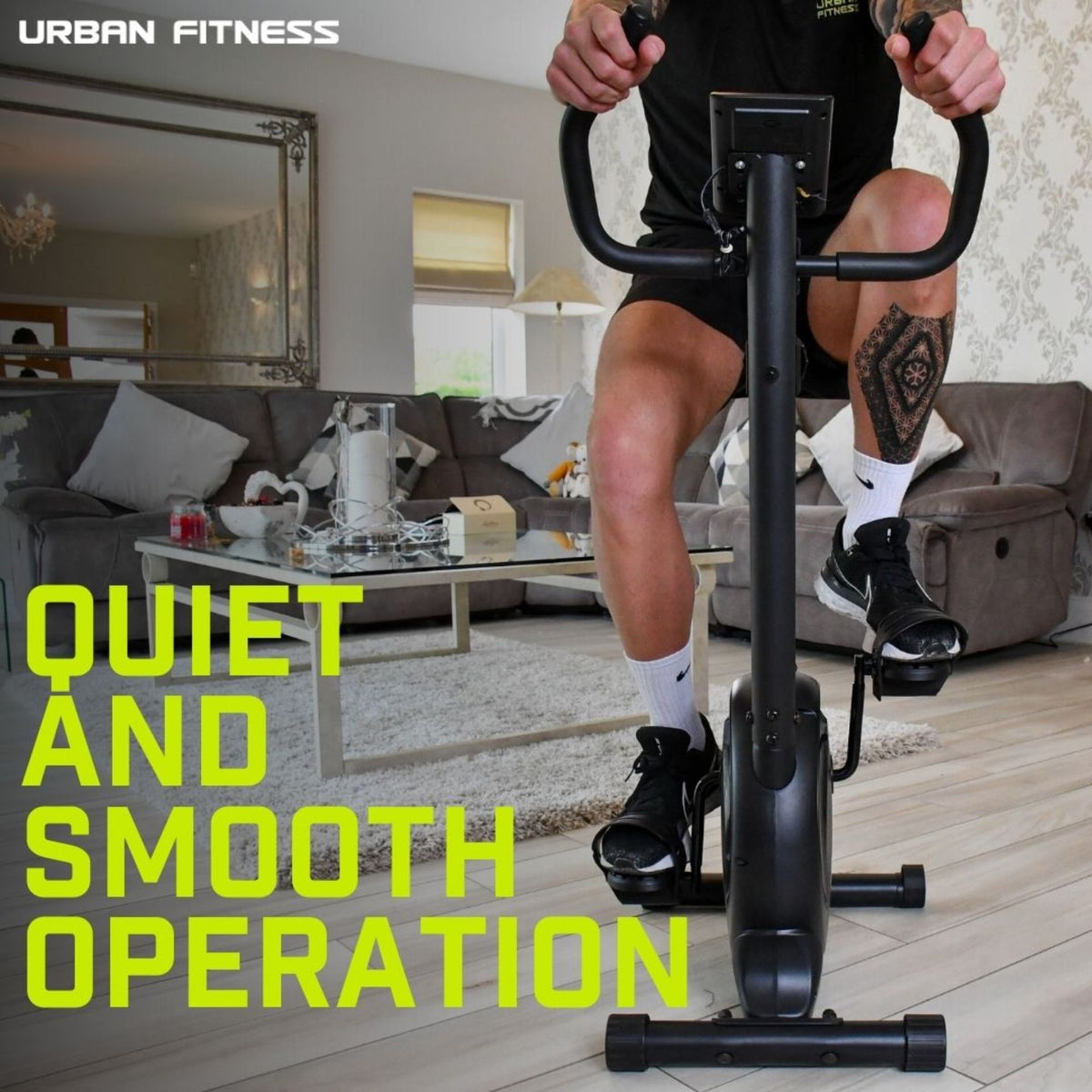 A person uses the Urban Fitness Magnetic Exercise Bike in a stylish living room. Bold yellow-green text reads "QUIET AND SMOOTH OPERATION," with "URBAN FITNESS" displayed in the top left corner.