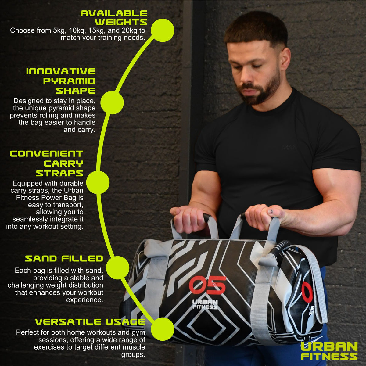 A man in a black shirt holds the Urban Fitness Power Bag (black, red 05, white pattern) by Urban Fitness. Features: multiple weights, pyramid shape, sturdy carry straps, sand-filled for full-body conditioning, and versatile use.