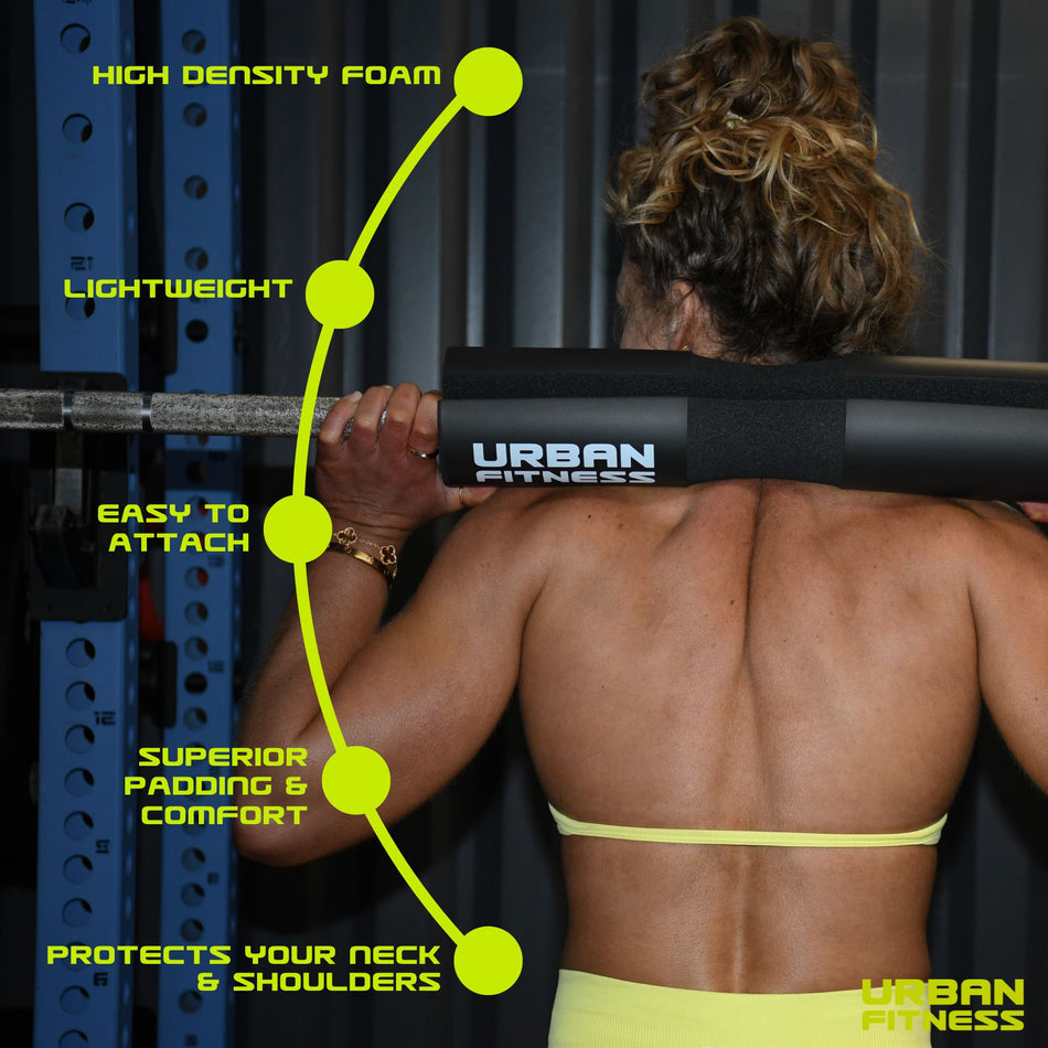 A woman with a muscular back lifts a barbell cushioned by the black Urban Fitness Barbell Squat Pad, which features high-density foam, lightweight design, easy attachment, superior comfort, and excellent neck and shoulder squat support.