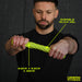 A man in a black shirt stretches the Urban Fitness Twist & Flex Resistance Bar, made of durable silica gel, sized 3.6cm x 3.2cm x 32cm—ideal for grip strength and injury recovery. Urban Fitness logo visible bottom right.