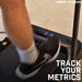 A person runs on the Urban Fitness Walking Treadmill, display showing 0.19. The Urban Fitness logo appears top right, with TRACK YOUR METRICS in bold white at bottom right, highlighting smart fitness tracking.