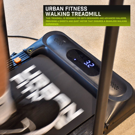 A person uses the Urban Fitness Walking Treadmill in black with smart fitness tracking; its digital display reads 3.2. The treadmill features "HERON" on the belt and suits both beginners and advanced walkers.