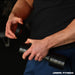 A person in a black shirt adjusts the quick-change weights on the Urban Fitness 2.5kg Adjustable Dumbbell Set in a gym, focusing on their hands and the equipment. The Urban Fitness logo appears at the bottom right corner of the image.