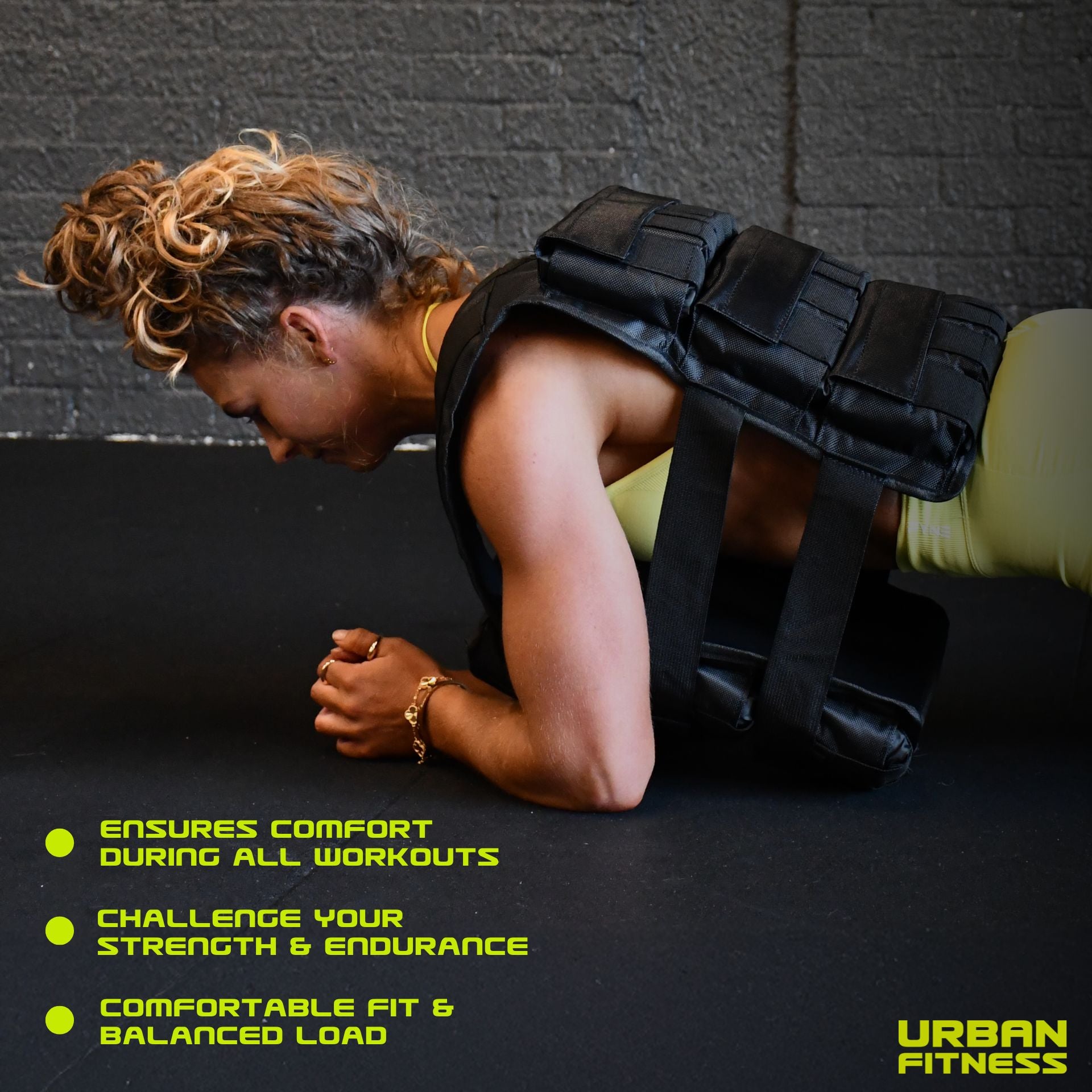 A woman wearing the Urban Fitness Adjustable Weighted Vest in black holds a plank on a gym floor. Text highlights comfort, boosted strength and endurance, and a balanced fit. The Urban Fitness logo appears at the bottom right.