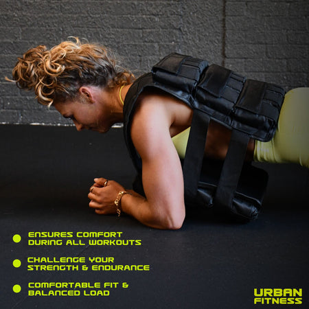 A woman wearing the Urban Fitness Adjustable Weighted Vest in black holds a plank on a gym floor. Text highlights comfort, boosted strength and endurance, and a balanced fit. The Urban Fitness logo appears at the bottom right.