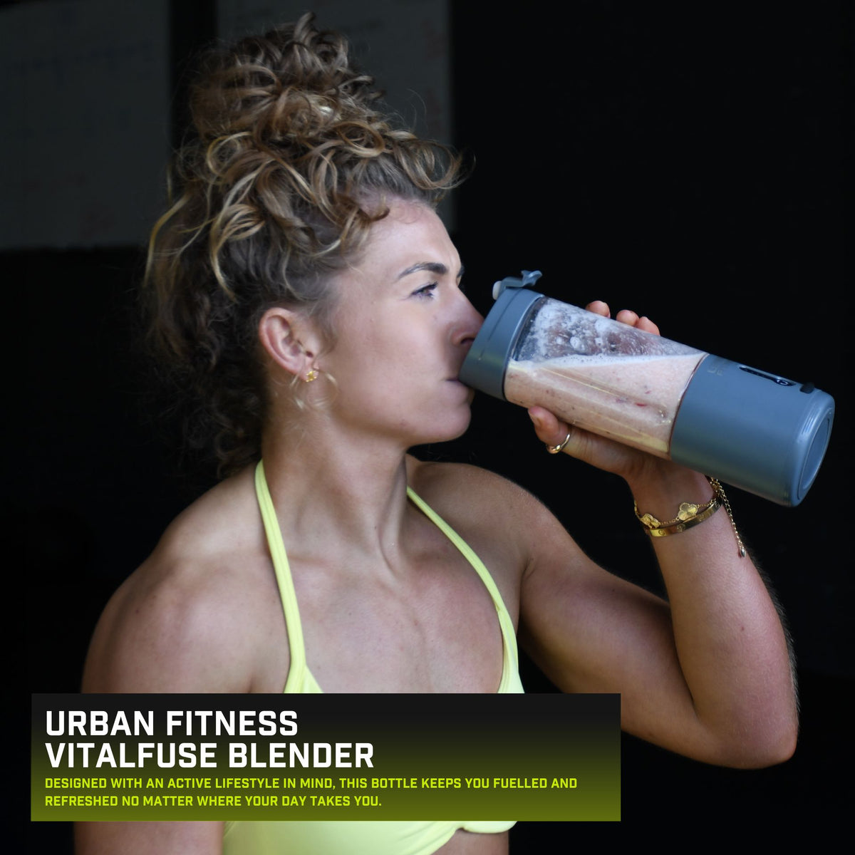 A woman in athletic wear drinks from the Urban Fitness VitalFuse Portable Blender, with the product name and description shown in the lower left corner, emphasizing on-the-go nutrition.