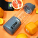 An Urban Fitness VitalFuse Portable Blender rests on an orange surface with orange dumbbells, a sliced grapefruit, and an orange nearby, highlighting vibrant on-the-go nutrition and a health-conscious lifestyle.