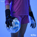 A person in a pink soccer kit holds a white and blue Precision soccer ball while wearing Precision Training Elite 3.0 Quartz Goalkeeper Gloves, known for maximum grip, against a blue background. Brand logos are visible.