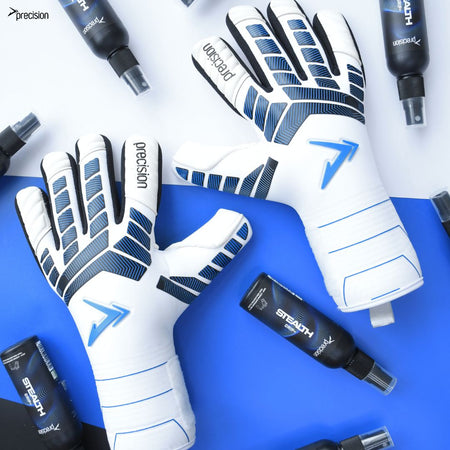 A pair of Precision Training Precision Elite 3.0 Giga Goalkeeper Gloves with elite grip rest on a blue and white surface, surrounded by several black STEALTH-labeled bottles.