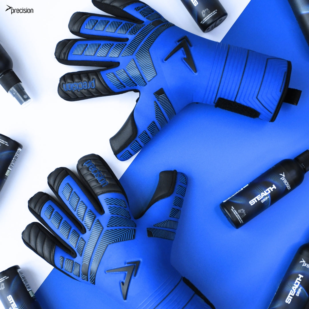 A pair of Precision Training Elite 3.0 Grip Goalkeeper Gloves in blue and black are displayed on a blue and white background, surrounded by black bottles of Precision Stealth sports spray for elite grip.