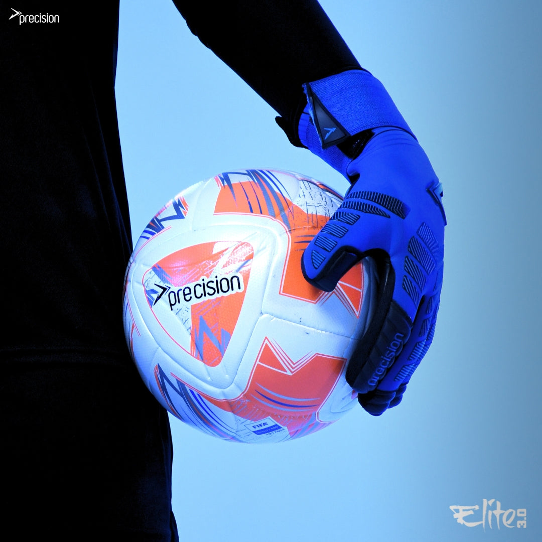 A person wearing Precision Training's Precision Elite 3.0 Grip Goalkeeper Gloves holds a white and orange soccer ball by their side, with blue lighting and brand logos highlighting the gloves' elite grip and style.