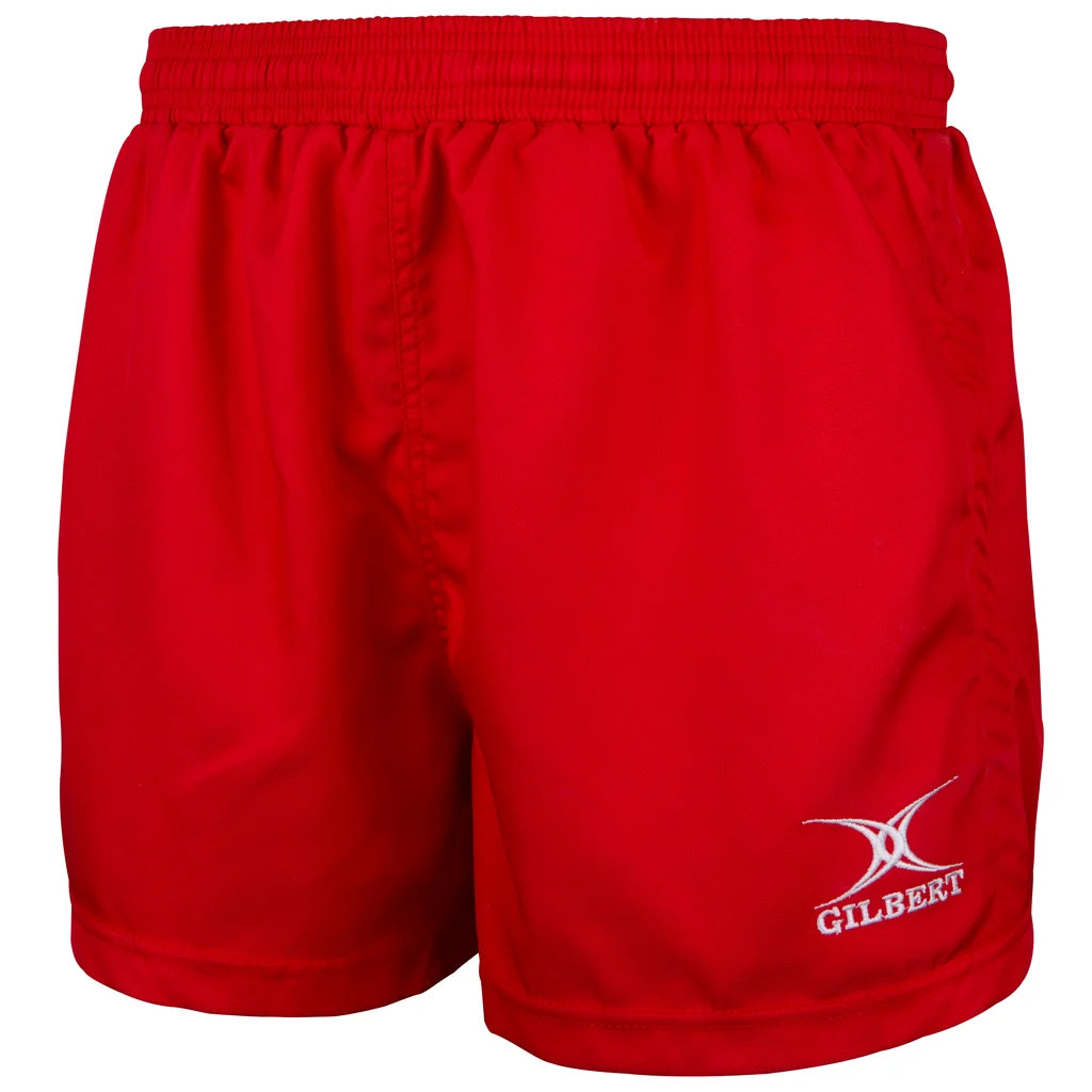 The Gilbert Saracen V3 Short – Junior in red features a bright, lightweight design with an elastic waistband. The word “GILBERT” and a white logo are embroidered on the front of the left leg. These junior shorts have a simple, plain style, making them an excellent choice for kids’ rugby gear.
