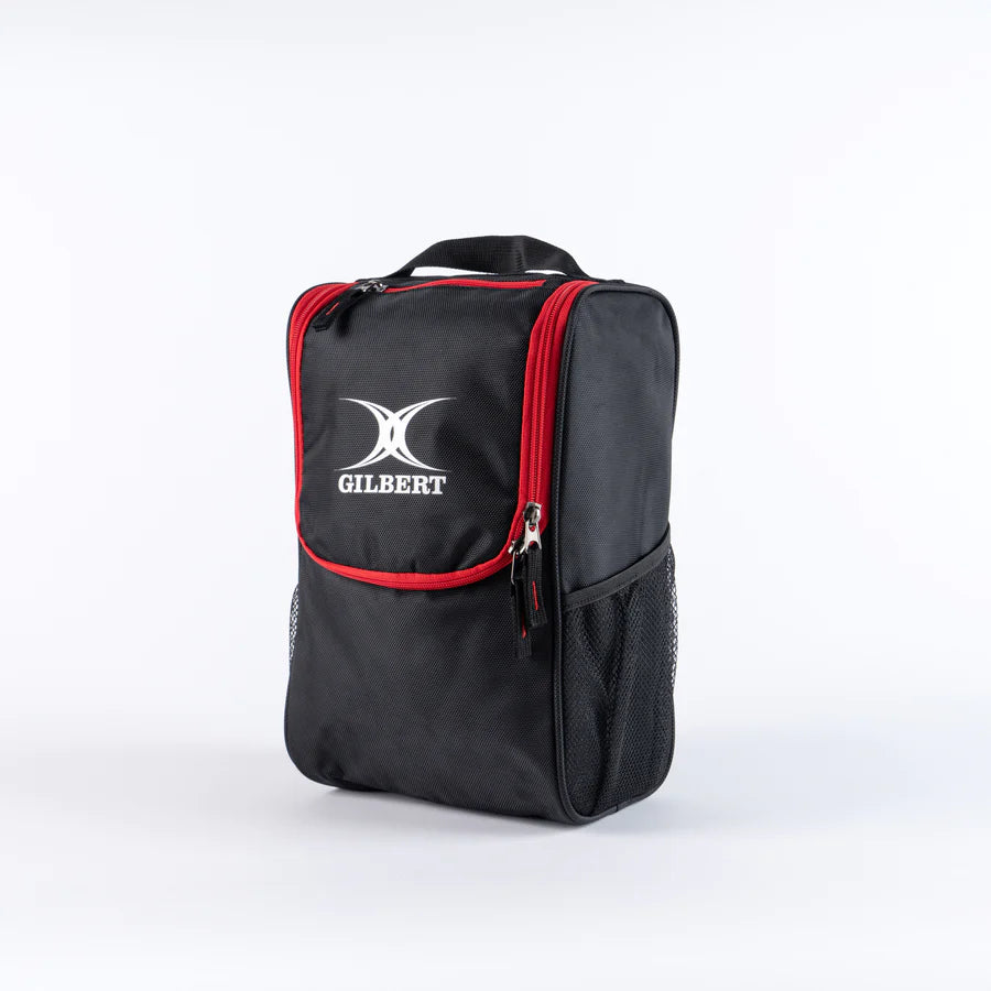 The black/red Gilbert Club V4 Boot Bag, featuring a front pocket, side mesh pocket, red zippers, and carrying handle, stands upright against a plain white background.