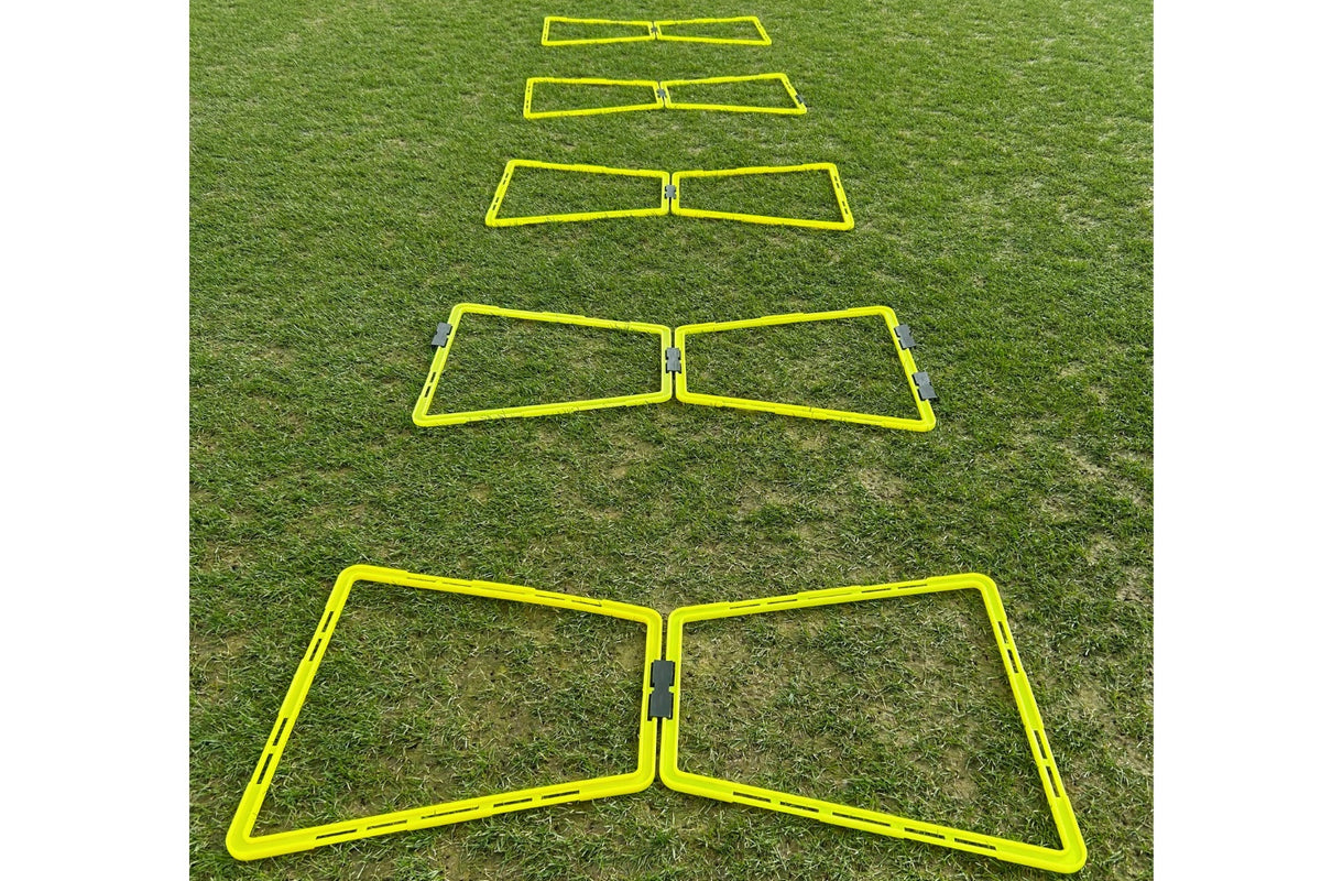 Six Samba Sports Samba Pro Agility Trapeze Set hurdles are lined up on green grass, fading into the distance—essential agility training equipment for speed and coordination drills.