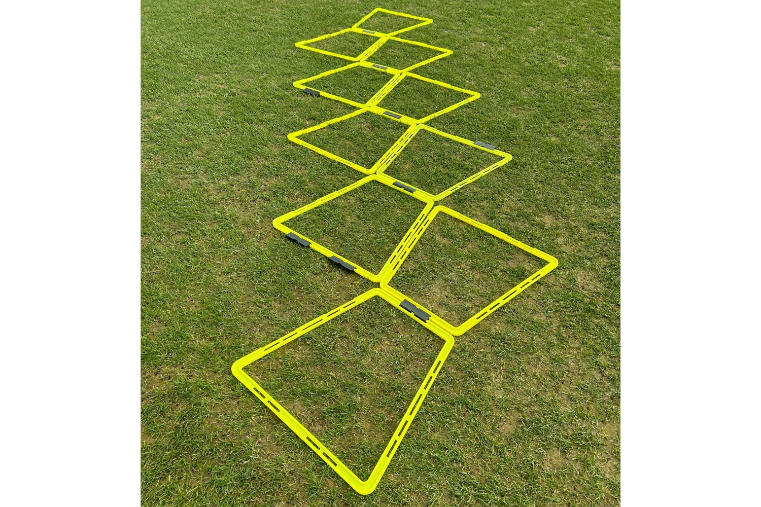 The Samba Sports Samba Pro Agility Trapeze Set, featuring yellow square rungs in a zigzag design on green grass, is essential training equipment to boost speed and coordination.