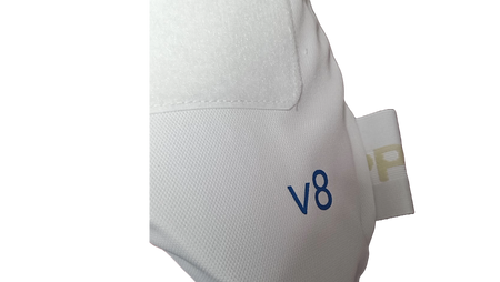 Close-up of Aero P1 Strippers V8 by Aero, featuring white textured fabric with "v8" in blue, EVA foam for hip protection, and a stitched tab with partial gold lettering on a plain white background.