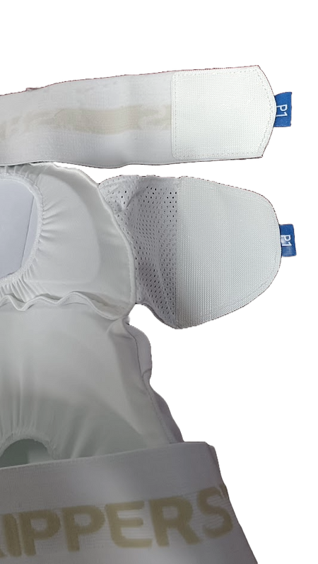 Close-up of the Aero P1 Strippers V8 by Aero, designed for cricket lower body protection. Features EVA foam padding, mesh fabric, adjustable Velcro straps, blue tags, and part of a gold PPERS logo for hip protection.