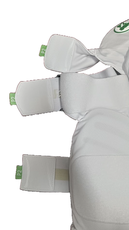 Close-up of three white fabric straps with green P2 tags on Aero P2 Strippers V8, designed by Aero for ultimate lower body protection, attached to EVA foam cricket pads against a white background.
