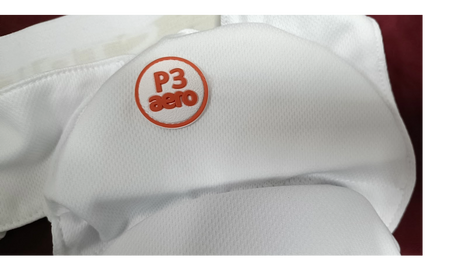 Close-up of the Aero P3 Strippers V8 by Aero, showing a white mesh fabric with a round orange and white "P3 Aero" patch, indicating ultimate lower body protection for junior cricket players.