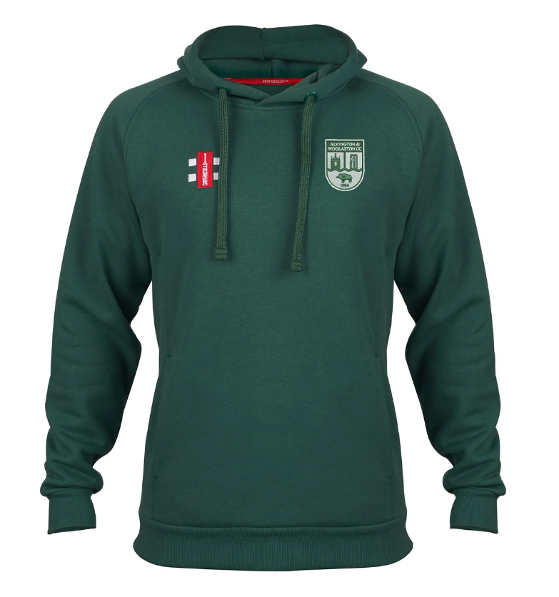The Alvington & Woolaston CC Velocity Hoodie by Gray Nicolls is a green hoodie made from sustainable cotton, featuring a front pocket, drawstrings, and two embroidered patches—white wickets on red and the Club Logo with buildings and a lion.