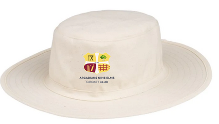 The Hunts County Arcadians Nine Elms CC Fielders Sun Hat is a cream wide-brim hat featuring the club logo and yellow and green shield emblems on the front.