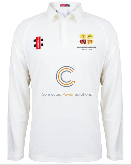 The Gray Nicolls Arcadians Nine Elms CC Matrix V2 Long Sleeve Cricket Shirt is a white top with moisture control, sponsor logos like Connected Power Solutions on the chest, and the club’s crest on the left side.