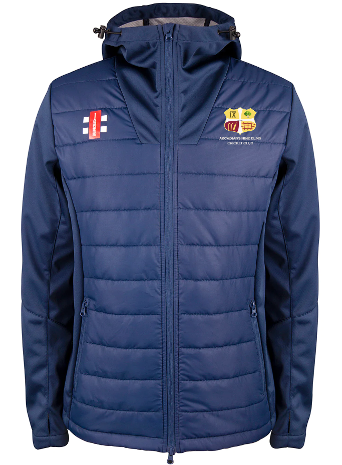 The Gray Nicolls Arcadians Nine Elms CC Pro Performance Full Zip Jacket is a navy blue, water-repellent jacket with zip closure, quilted front, side pockets, and embroidered cricket club logos and badges on the chest.