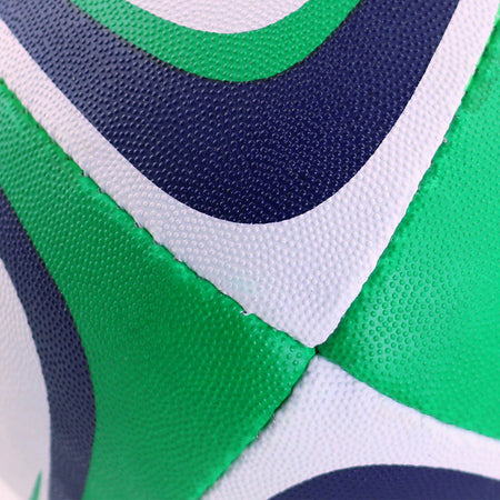 Close-up of a textured, water-repellent Centurion Nemesis Trainer Rugby Ball with stitched panels and white, green, and dark blue curved shapes.