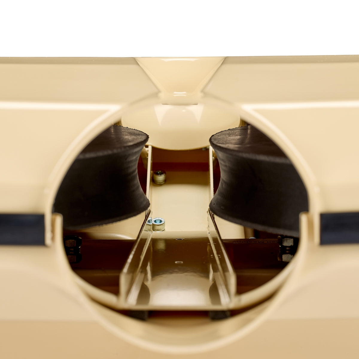Close-up view of the inside of a beige plastic model boat, highlighting two black rubber components and a central screw with a metallic support structure—details reminiscent of the precise interior mechanisms featured in the Bola Hockey Machine by Bola.