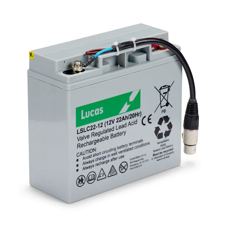 A Bola valve regulated lead acid rechargeable battery with attached cables and connector, designed for use with the BOLA Junior Bowling Machine during junior cricket practice. The gray battery casing features a label displaying technical details, safety warnings, and icons.