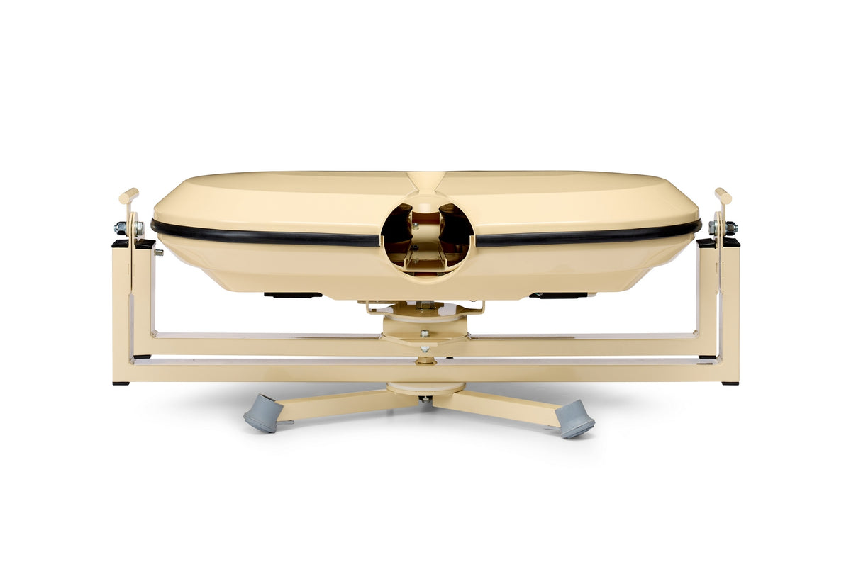 Beige, oval-shaped Bola Fielding Training Machine by Bola—vintage medical device aesthetic with a central opening, echoing the precise engineering found in Gimballed Turntable systems—mounted on a metal stand with four gray feet and photographed against a white background.