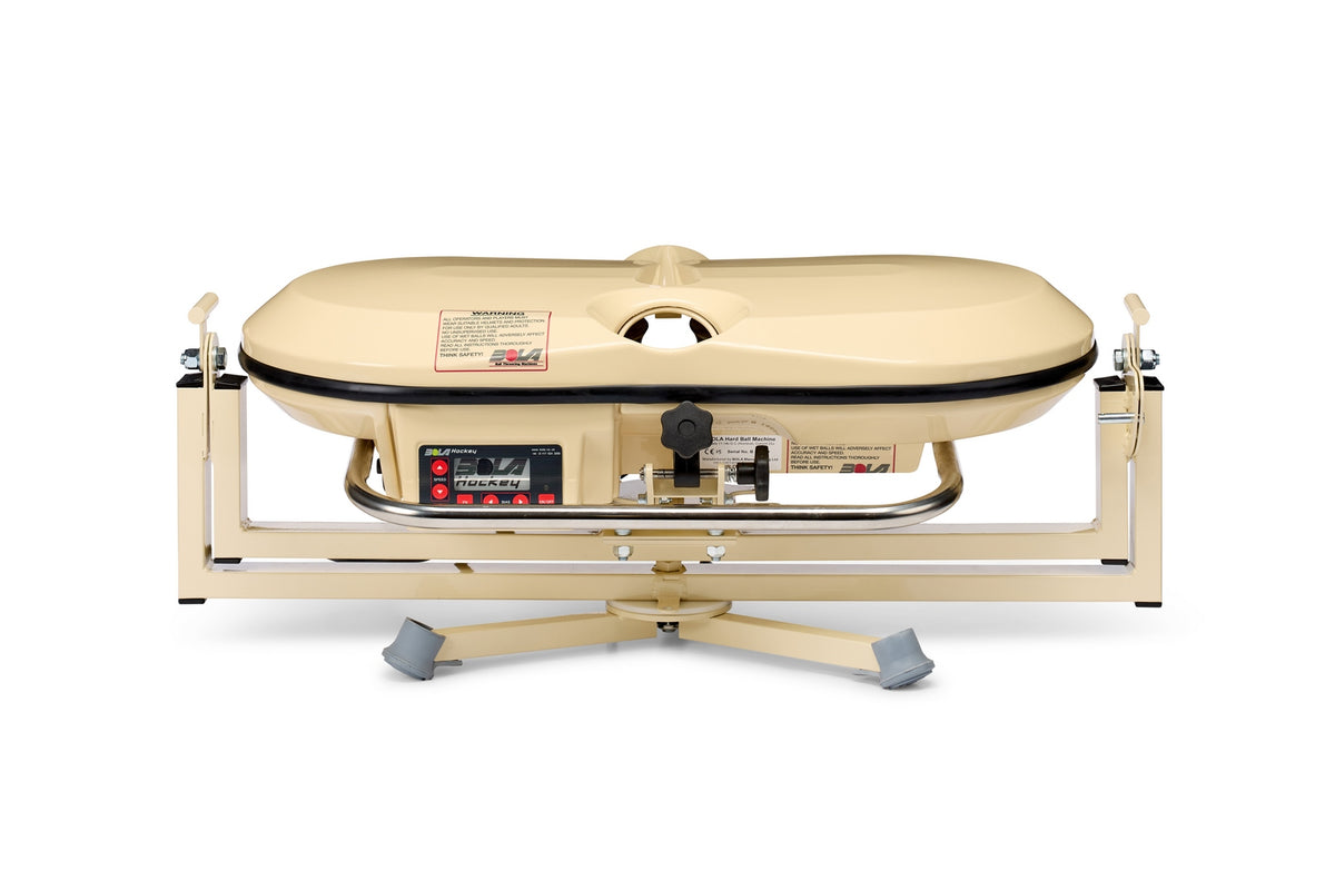 A Bola Fielding Training Machine from Bola, featuring a beige body with a digital control panel and a contoured tray, designed for precision practice sessions; it rests on a sturdy metal base with gray foot pads reminiscent of the stability found in a gimballed turntable.