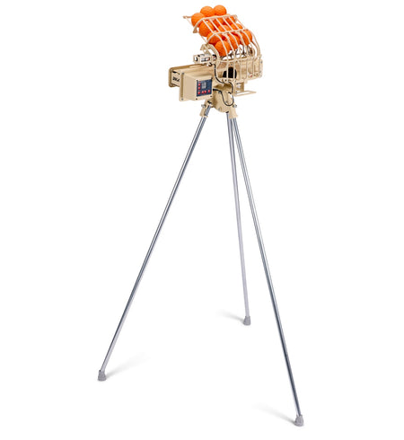 The BOLA Junior Bowling Machine by Bola, in beige, is positioned on a tall silver tripod with four orange tennis balls loaded on top, making it perfect for junior cricket practice. The automatic machine stands out elegantly against a white background.