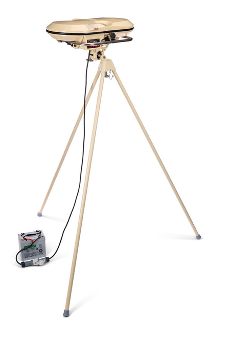 A tan clay pigeon thrower, featuring a tall tripod stand and a build reminiscent of the robust Bola Professional Bowling Machine by Bola, is connected via cable to a battery box on the floor, all set against a white background.