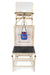 A beige medical testing station featuring a black bench, adjustable platform, hanging blue bag with red balls, and white backboard is positioned next to the Bola Bowling Machine Stand on Wheels by Bola, seamlessly blending function and versatility in the space.