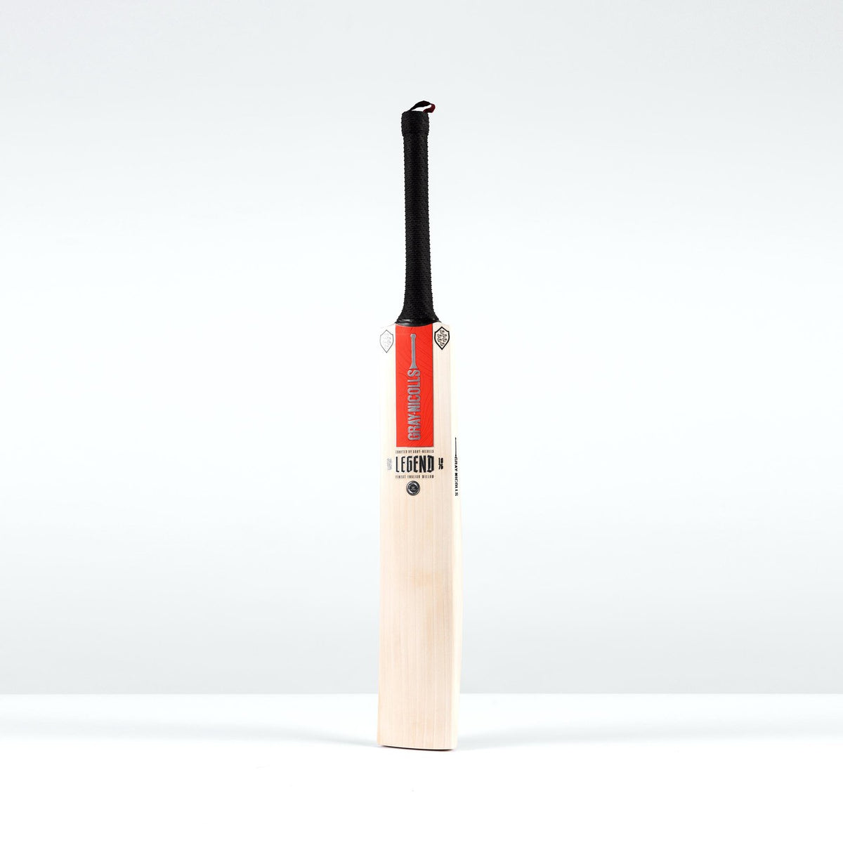 The Gray Nicolls Legend Platinum Edition SH Cricket Bat, featuring a light premium English willow blade, black gripped handle, and red label at the top, stands upright against a plain white background.