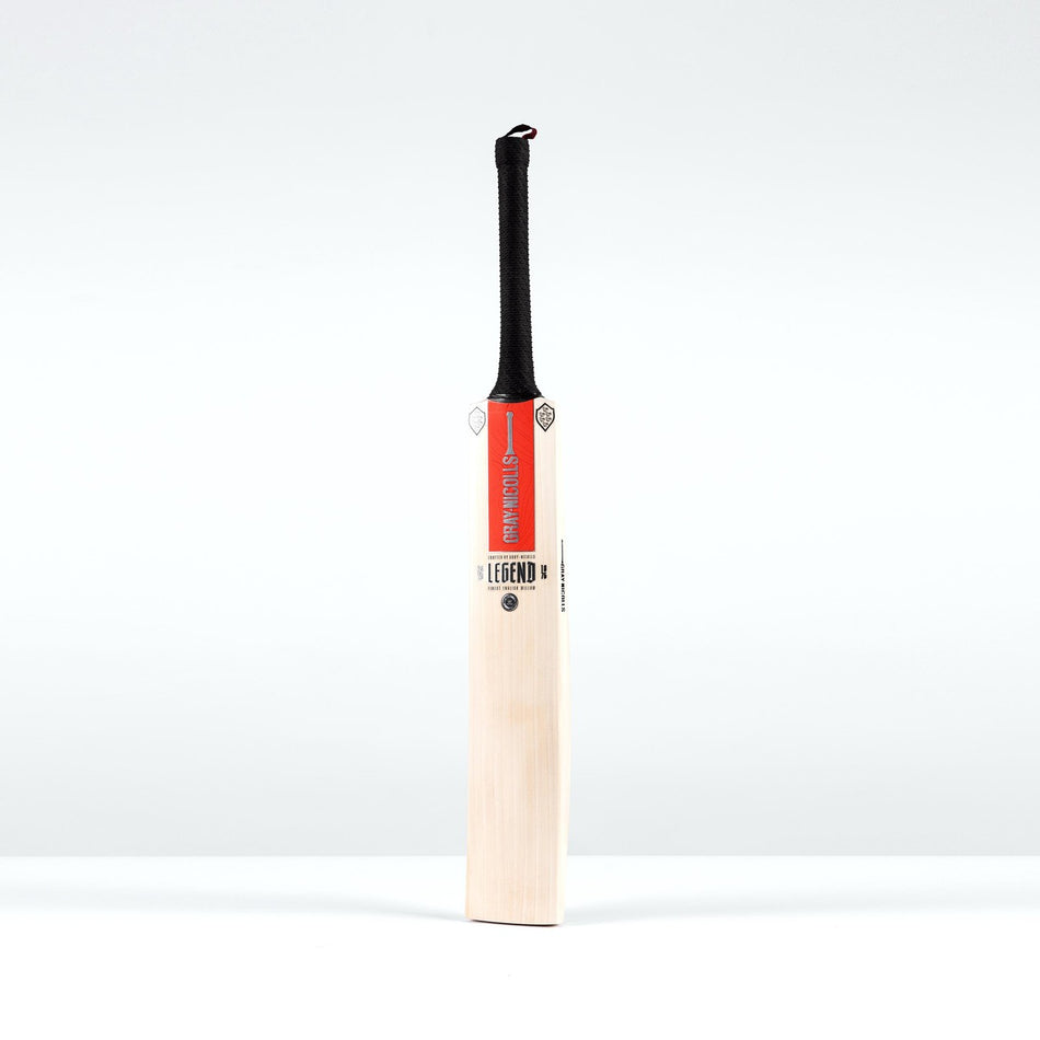 The Gray Nicolls Legend Platinum Edition SH Cricket Bat, featuring a light premium English willow blade, black gripped handle, and red label at the top, stands upright against a plain white background.