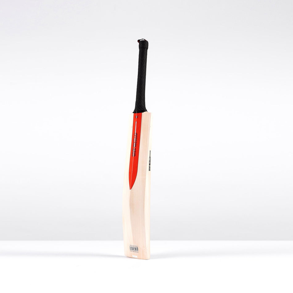 The Gray Nicolls Legend Platinum Edition SH Cricket Bat, crafted from premium English willow with a black grip and red blade stripe, stands upright against a plain white background.