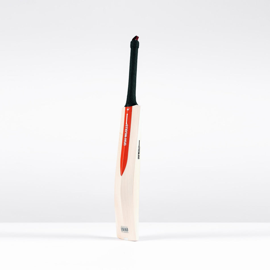 The Gray Nicolls Legend Silver Edition Junior Cricket Bat, a wooden English willow bat with a black handle and red and white sticker, featuring an expanded sweet spot, stands upright against a plain white background.