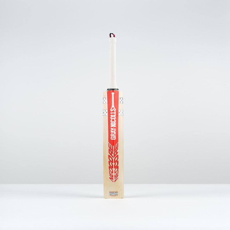 The Gray Nicolls Neocore Pro SH Cricket Bat 2026 stands upright on a plain light gray surface, featuring a Pro Shape with a red and white design, set against a light gray background.