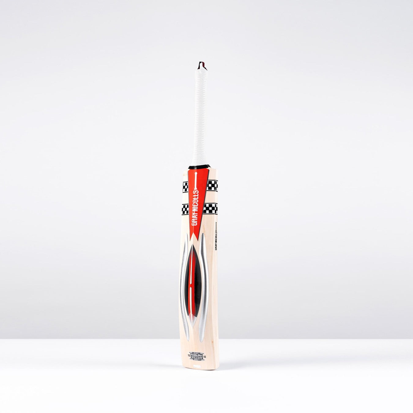The Gray Nicolls Powerscoop 500 SH Cricket Bat, featuring light wood with red, black, and white graphics, stands upright against a plain light background.