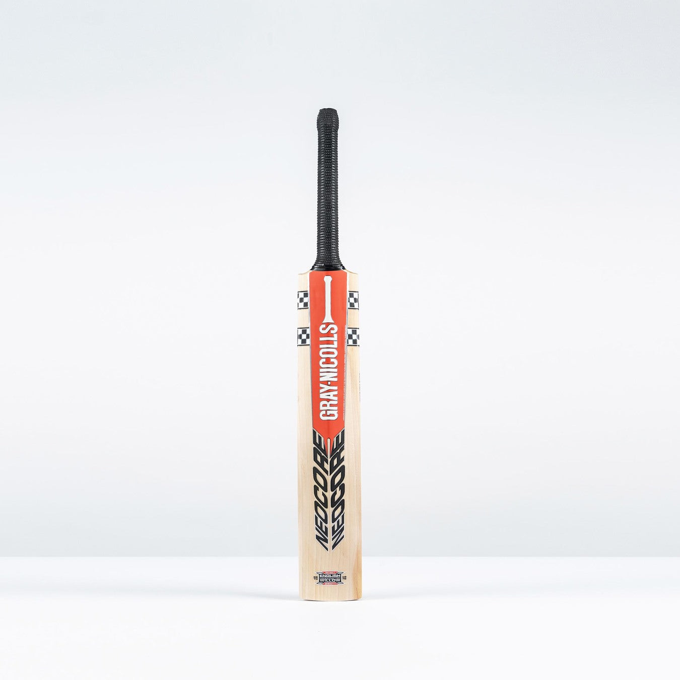 The Gray Nicolls Neocore 500 Harrow Cricket Bat 2026 stands upright with a black handle and red-and-black branding against a plain white background.